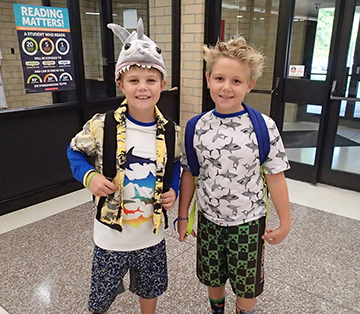 Two male students wearing shark themed attire pose together